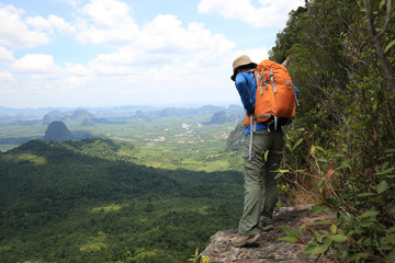 Fototapeta na wymiar young woman backpacker hiking at seaside mountain cliff