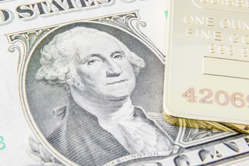 US one dollar bill with image / portrait of George Washington and gold bullion. A concept of the two most popular currency reserve in all countries in the world. © William W. Potter
