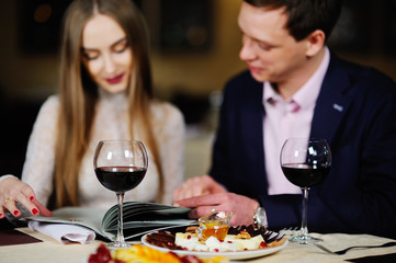 guy with a girl in a restaurant choose dishes from the menu