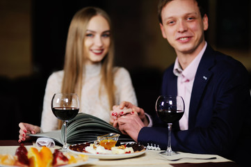 guy with a girl in a restaurant choose dishes from the menu