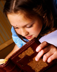 Little girl in a blue dress on the floor in room reading a book