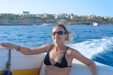 Attractive smiling girl sailing on a yacht on summer day