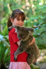 Foto auf Acrylglas Koala Kleines Mädchen, das einen Koala hält