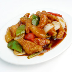 asian food - sweet and sour pork with fruit salad on white dish