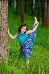 Naklejka na ściany i meble beautiful little girl with curly hair in nature, sunny smile