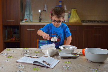 Little child chief cooking cookies in the kitchen