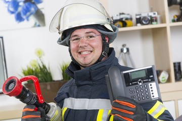 Feuerwehrmann mit Telefon Notruf 112