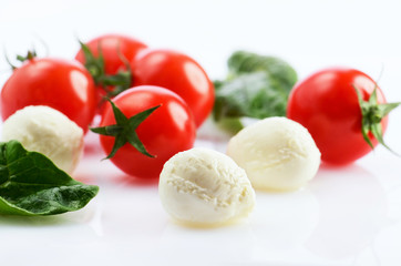 three mozzarella cheese balls and five ripe cherry tomatoes and