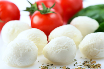 Fototapeta na wymiar mozzarella cheese balls, ripe cherry tomatoes, greens and spices