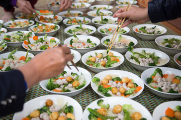 Vietnamese traditional bowl of mixed food including fried egg, fork, onion, cauliflower, carrot, and soup