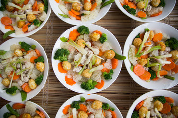 Vietnamese traditional bowl of mixed food including fried egg, fork, onion, cauliflower, carrot, and soup