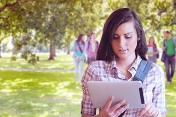 Fototapeta premium Composite image of young focused student using a tablet computer