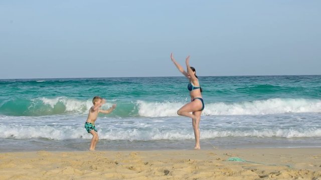 A boy and his mom jumping on a beach in Corralejo on Fuerteventura, one of the Canary islands. Rendered as slow motion. Original, 100 fps