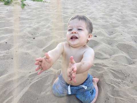 Baby boy playing with sand on beach