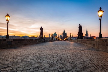 Charles Bridge at sunrise, Prague, Czech Republic. Dramatic statues and medieval towers.
