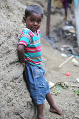 Pune, India - July 16, 2015: A poor Indian boy standing at a con