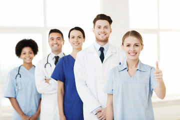 happy doctors showing thumbs up at hospital