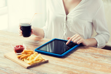 close up of woman with tablet pc and fast food