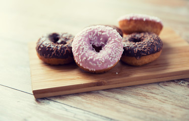 close up of glazed donuts pile on wooden table