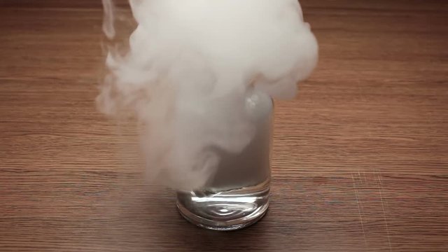 Pouring boiled water into jar with a piece of dry ice