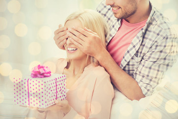 happy man giving woman gift box at home