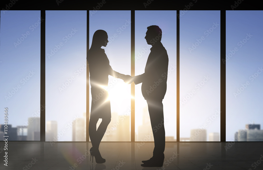 Wall mural business partners silhouettes shaking hands