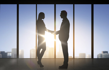 Fototapeta na wymiar business partners silhouettes shaking hands