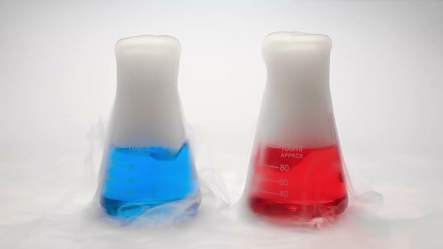 Two small conical flasks with red and blue fuming liquid