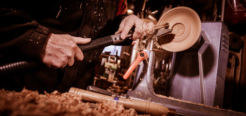Woodturners using a rotating clamp to turn the wood.