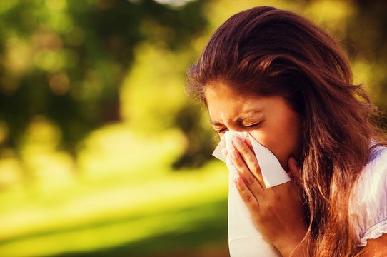 Woman Blowing Nose With Tissue Paper At Park