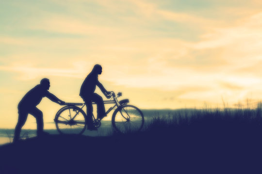 silhouette of couple driving bike happy time sunset
