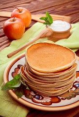 Stack of pancakes with mint and sour cream