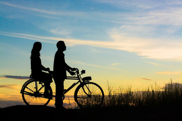 Obraz na płótnie Canvas silhouette of couple driving bike happy time sunset