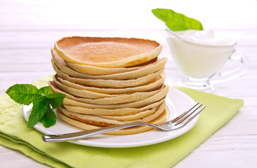 Stack of pancakes with mint and sour cream