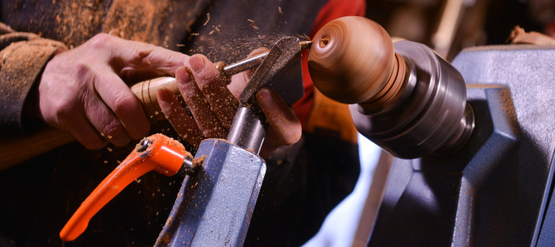 Woodturners using a rotating clamp to turn the wood.