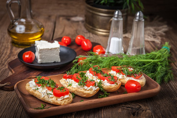 Delicious bruschetta with tomatoes, feta cheese, dill and spice