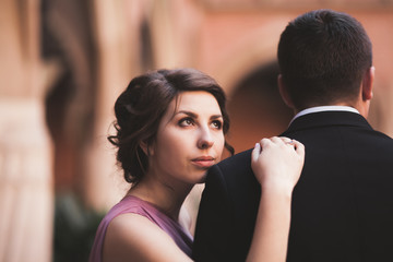 Young couple in love bride and groom posing near area with white columns on the background. Krakow