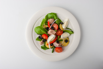 Nicoise salad with tuna on white ceramic plate