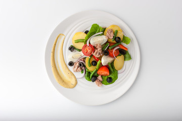 Nicoise salad with tuna on white ceramic plate