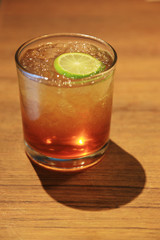 A glass of iced tea with lemon on the wooden table