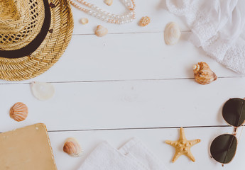 Sunglasses, hat and  book on a wooden background. Top view