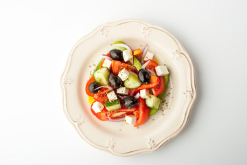 Greek salad on a relief plate on a white background