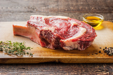 Great Steak on the bone with thyme on cutting board