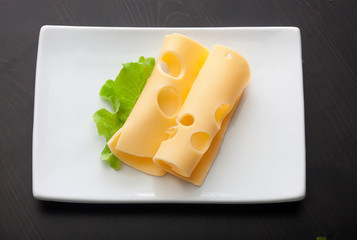 Two pieces of maasdam cheese with green lettuce