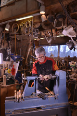Woodturners using a rotating clamp to turn the wood.
