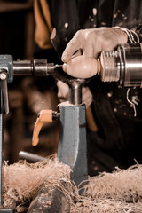 Woodturners using a rotating clamp to turn the wood.
