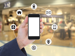 Hand holding blank screen mobile phone on blurred shopping mall