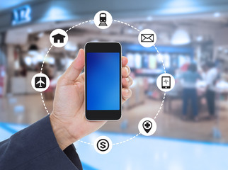 Hand holding blank screen mobile phone on blurred shopping mall