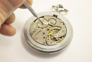 Hand repairs mechanical watch. Isolated