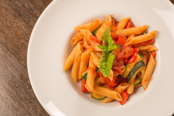 close up of pasta with tomatoes, zucchini and basil